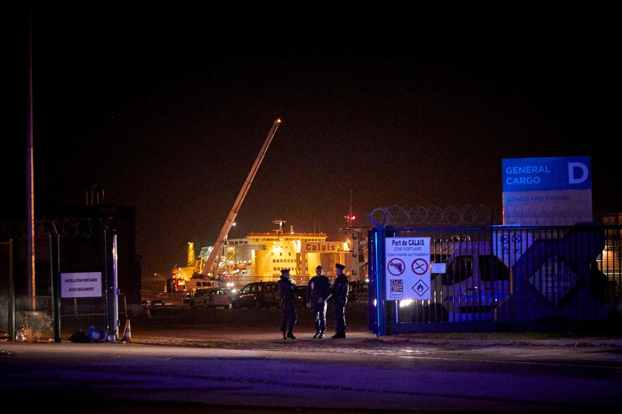 Police seal off the area around the rescue operation at Calais harbour in France on Nov. 24