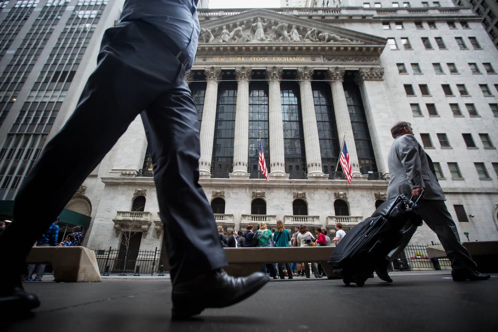 Pedestrians walk past the New York Stock Exchange.