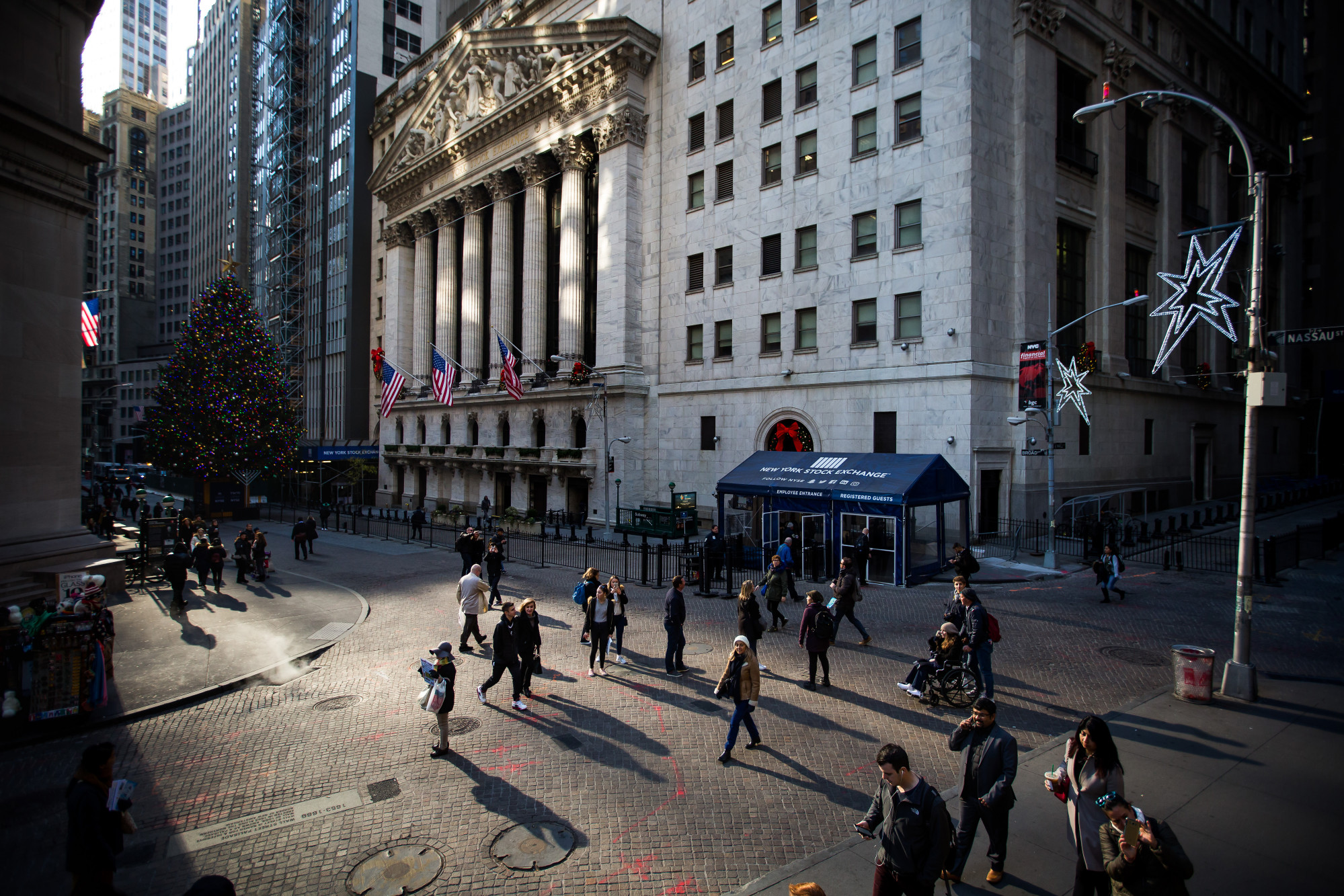 Pedestrians pass in front of the New York Stock Exchange (NYSE) in New York, U.S., on Friday, Dec. 1, 2017.