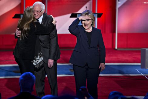Hillary Clinton looks toward the audience as Bernie Sanders hugs his wife, Jane, at the conclusion of a Democratic presidential debate at the University of New Hampshire in Durham on Feb. 4, 2016.