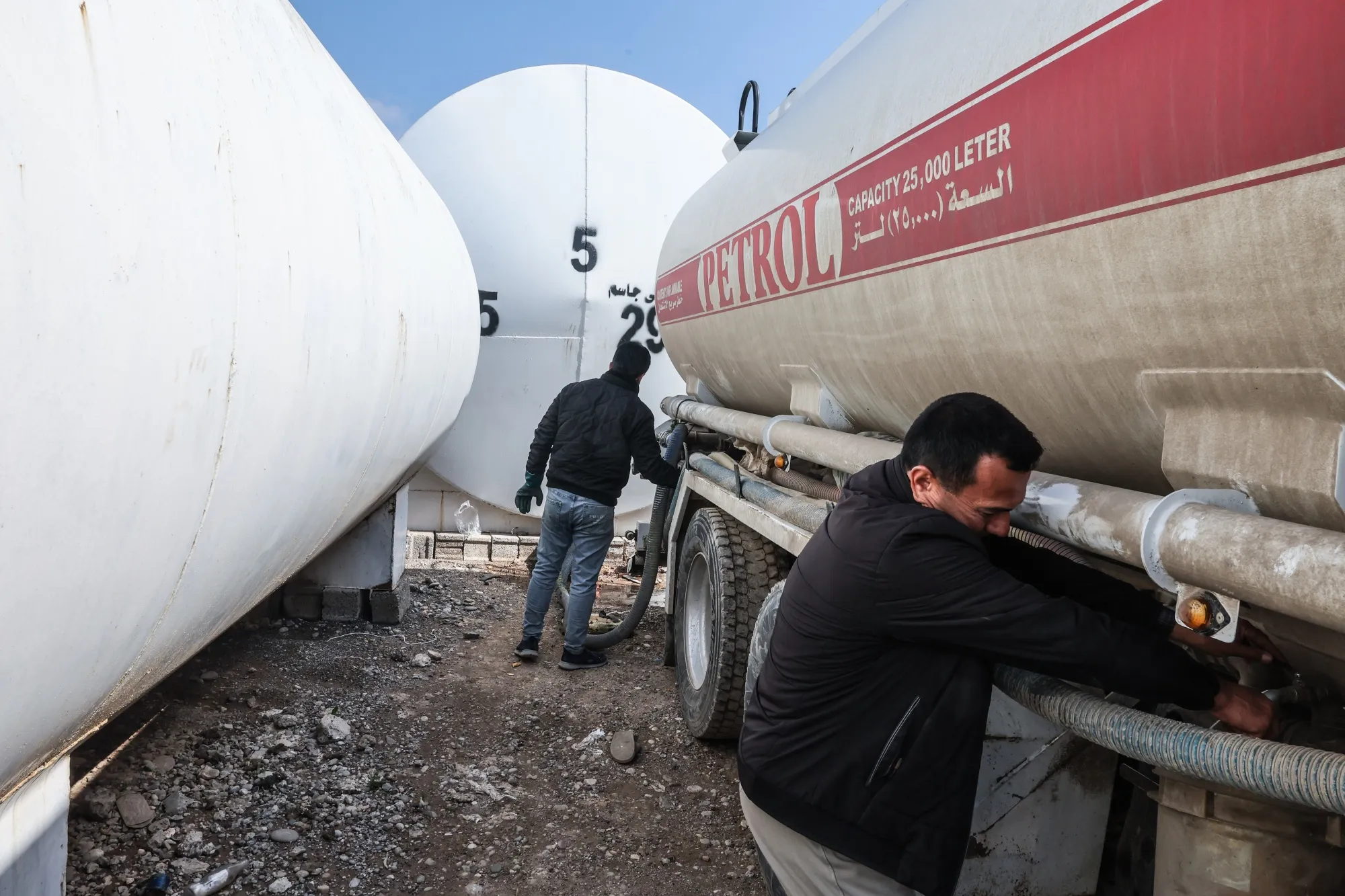 Men stand near tank trucks at a market for fuel oil and automotive fuel in Erbil, Iraq on March 17.