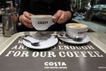 A barista places a coffee on to a serving tray in a Costa Coffee shop, operated by Whitbread Plc, in London, U.K., on Wednesday, May 2, 2018. Whitbread is betting that its faster-growing Costa Coffee chain will compete more effectively against the likes of Starbucks Corp. once separated from the company's hotel business.