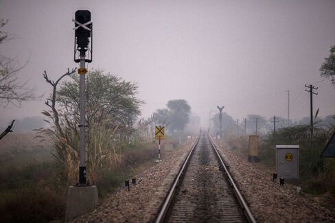 Rail tracks pass through a clearing where villagers go to defecate