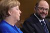 Martin Schulz, leader of the Social Democrat Party (SPD), right, looks towards Angela Merkel, Germany's chancellor