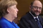 Martin Schulz, leader of the Social Democrat Party (SPD), right, looks towards Angela Merkel, Germany's chancellor