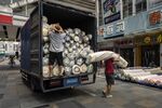 Workers move rolls of fabric in the Haizhu district of Guangzhou in September.