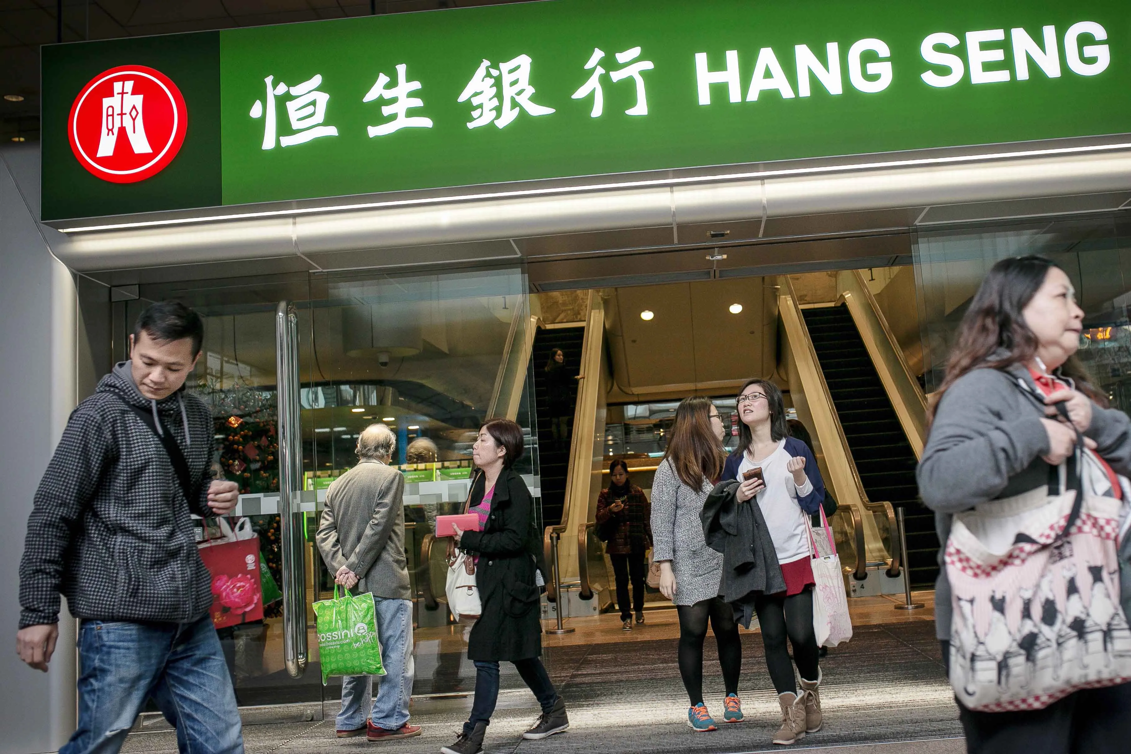 Pedestrians walk past Hang Seng Bank headquarters in Hong Kong.
