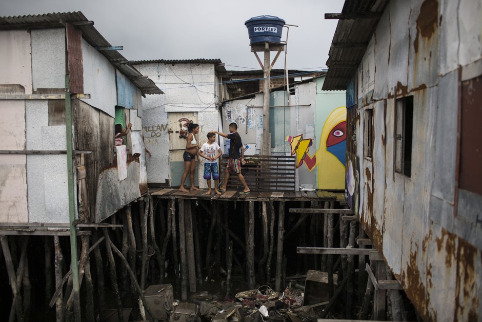 Residents stand outside stilt homes over polluted water in a slum in Recife, Brazil. 