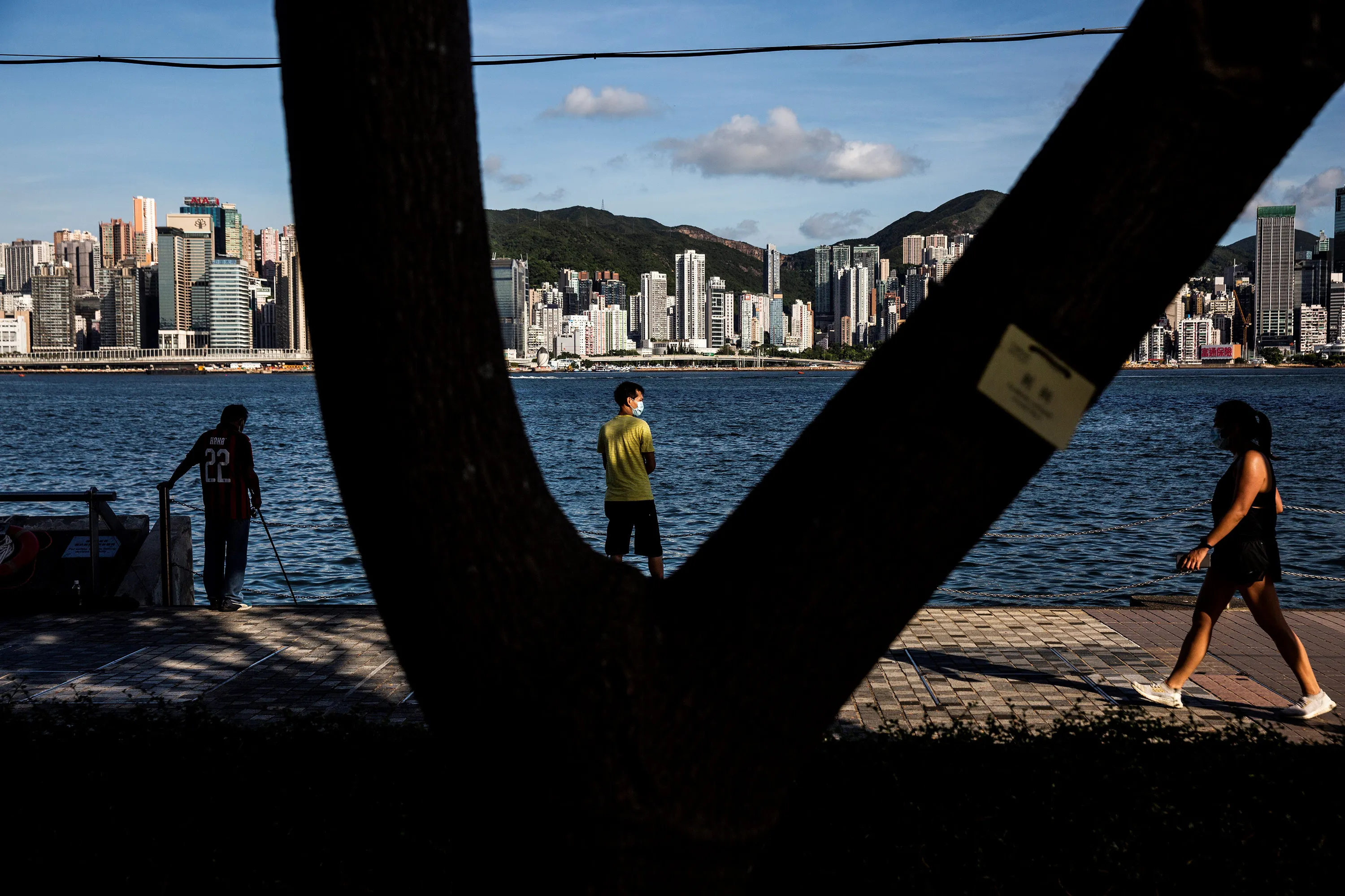 A man fishes along the promenade next to Victoria Harbour in Hong Kong.