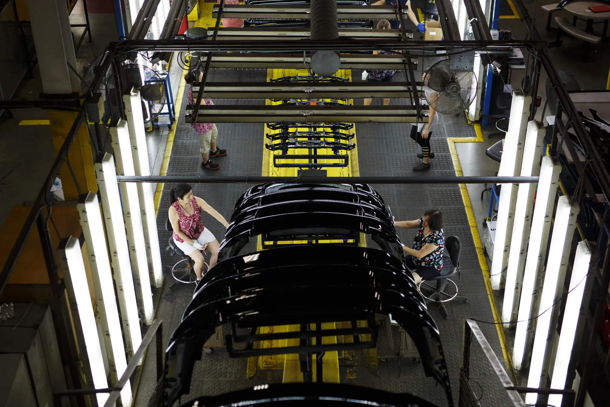 Employees work on the floor at the Magna International Inc. Polycon Industries auto parts manufacturing facility in Guelph, Canada, in 2018.
