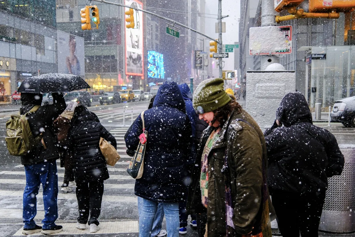 People walk on the street as it snows in New York on Jan. 17.&nbsp;