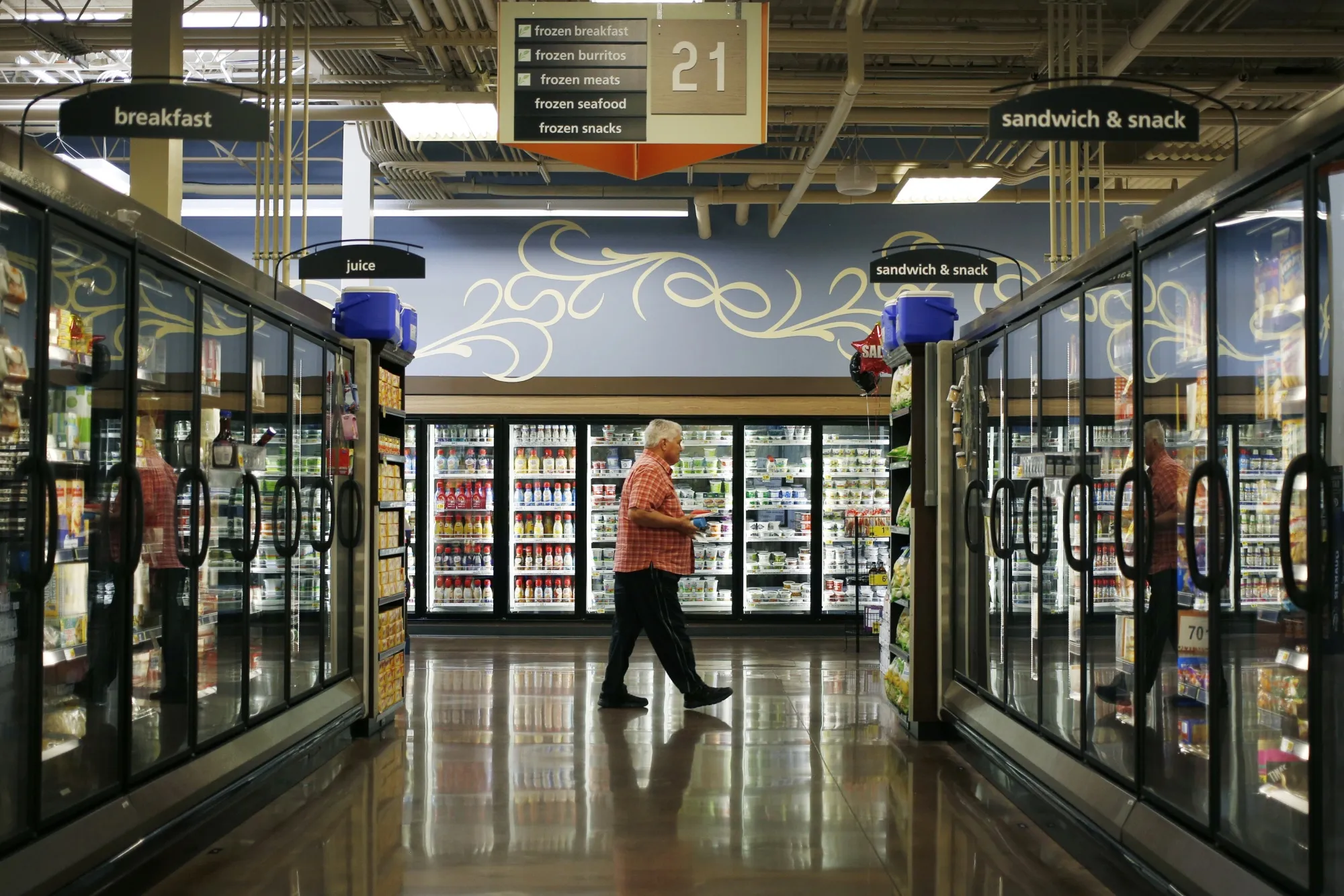 A customer walks past through the frozen food aisle inside a grocery store in Louisville, Kentucky.