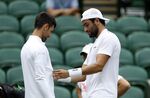Italy's Matteo Berrettini checks out the clothing worn by Serbia's Novak Djokovic on centre court ahead of the 2022 Wimbledon Championship at the All England Lawn Tennis and Croquet Club, Wimbledon, Thursday June 23, 2022. (Steven Paston/PA via AP)
