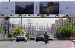 Cars drive past billboards in the Iranian capital of Tehran displaying art pieces from local and foreign artists.