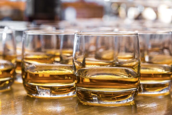 Glasses are filled with whiskey on the table