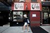 A pedestrian passes in front of Rue B jazz cafe temporarily closed in New York, U.S.