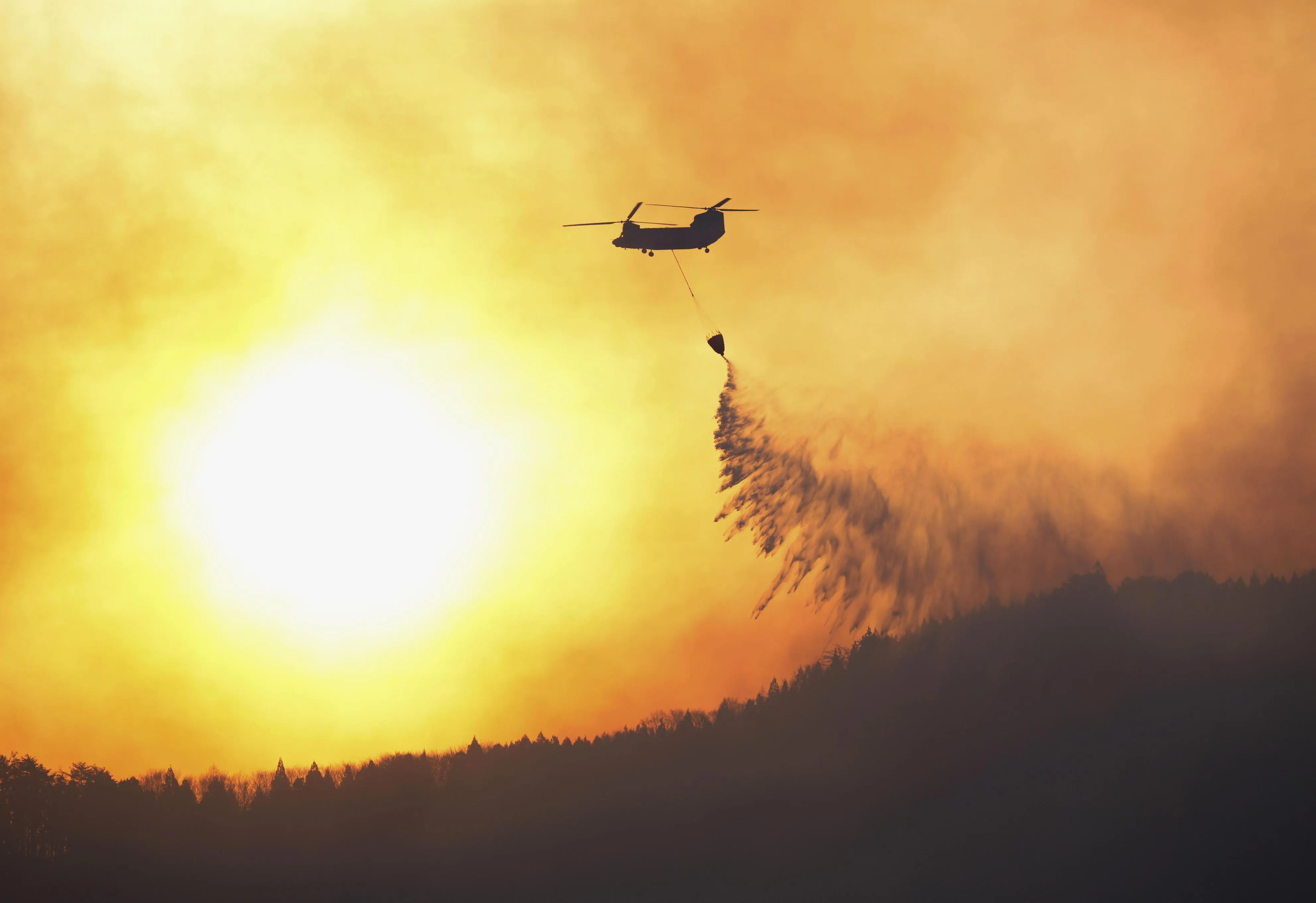 A Japan Self-Defense Forces helicopter attempts to extinguish a forest fire in a mountainous area in Ofunato in Iwate Prefecture on March 4.