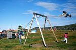 Inuit children play on the swings in the village of Ilimanaq, Greenland