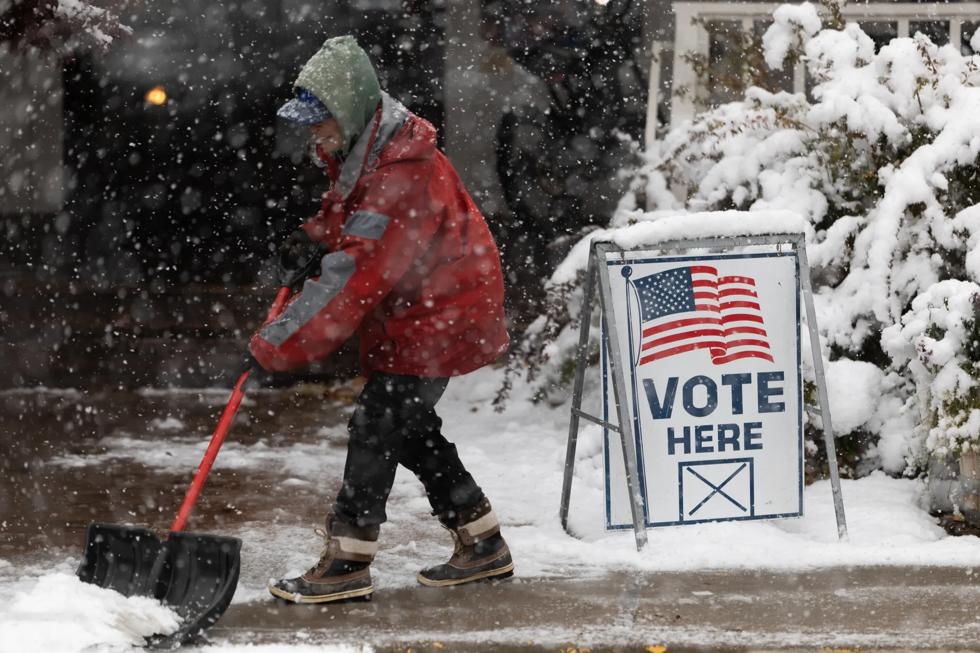 A Washoe County employee shovels snow outside of a vote center in Reno on Nov. 8.
