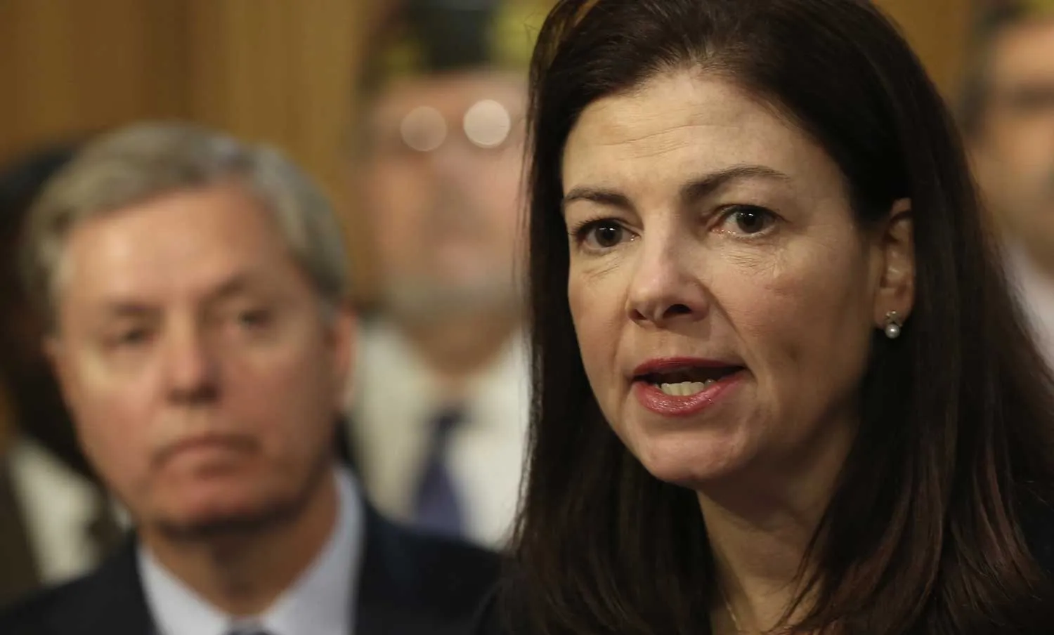 U.S. Sen. Kelly Ayotte (R-NH) (C) speaks as she participates in a news conference with Sen. Lindsey Graham (R-SC) (L) and veteran groups December 17, 2013 on Capitol Hill in Washington, DC. Sen. Kelly Ayotte (R-NH), Sen. Lindsey Graham (R-SC) and Sen. Roger Wicker (R-MS) held a news conference to discuss their opposition on the Ryan-Murray Bipartisan Budget Act of 2013 due to a provision that reduces cost of living benefits for many military retirees under age of 62
