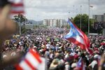 Demonstrators march on a highway blocking traffic during a protest in San Juan, Puerto Rico, on Monday, July 22, 2019.