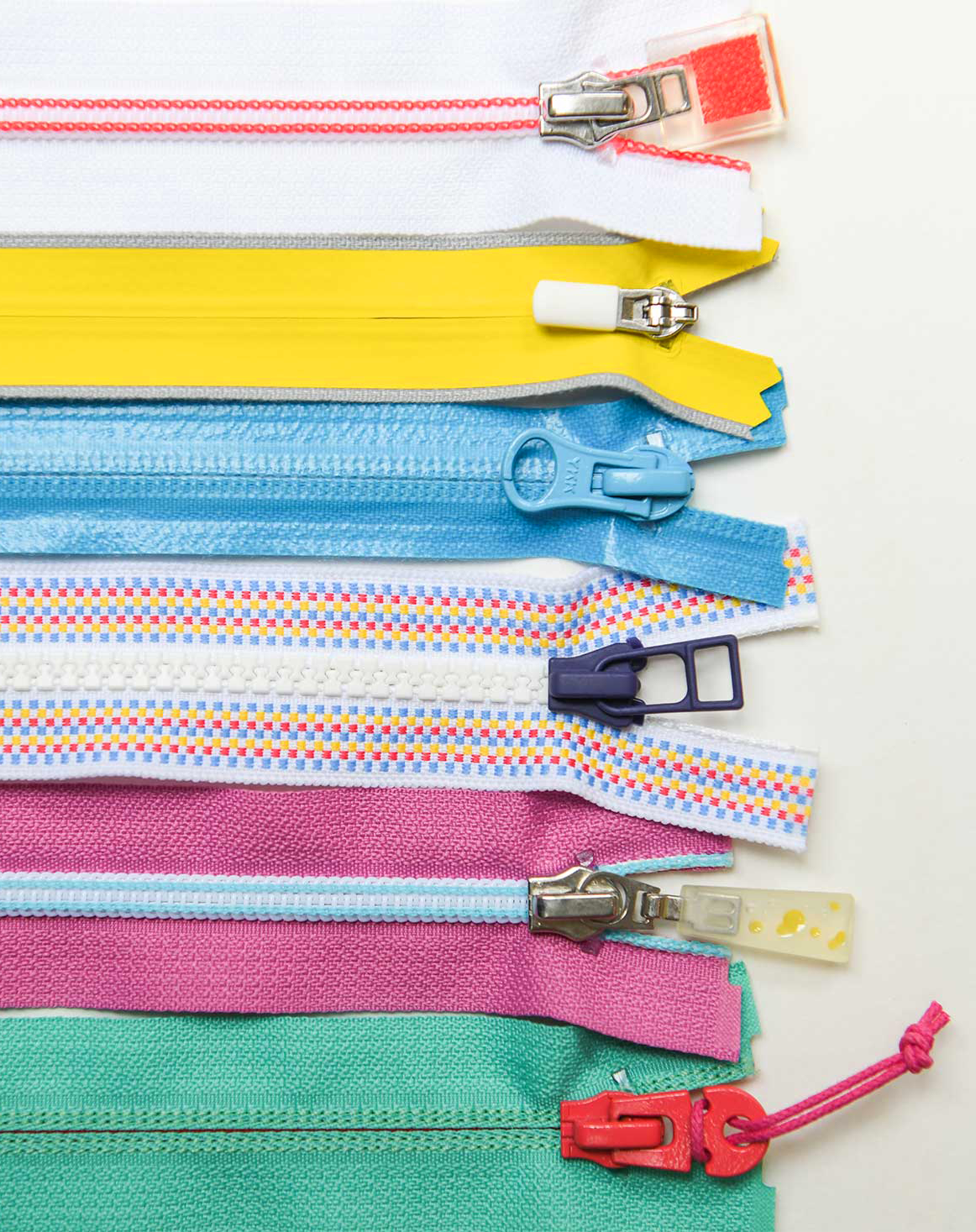 A selection of colorful zippers with unique zipper pulls and hardware.