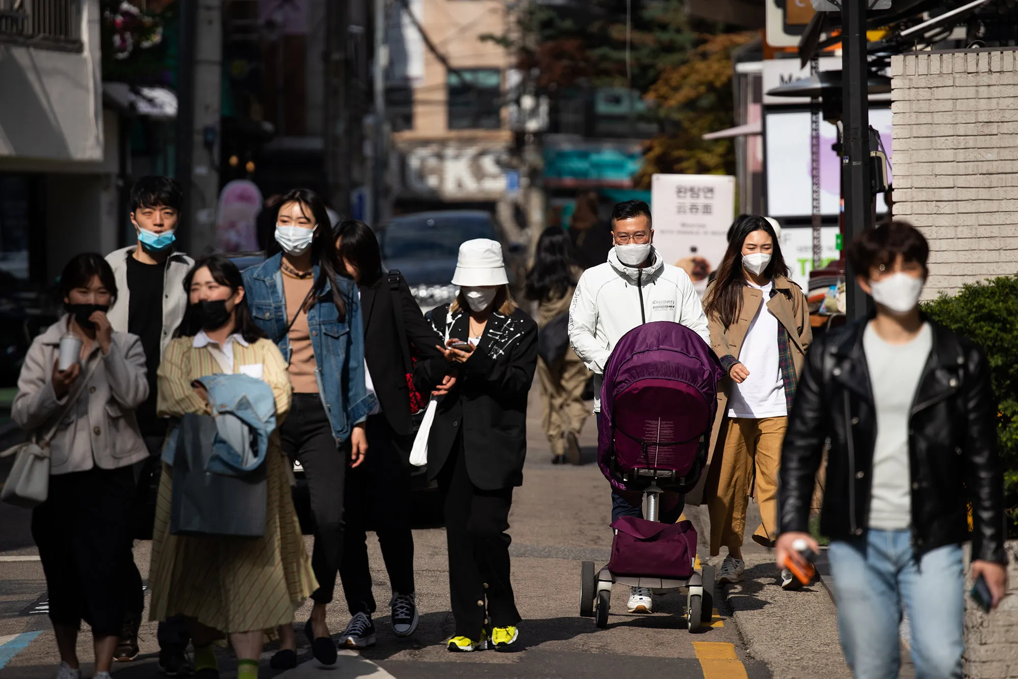 People walk through the Garosu-gil neighborhood of the Gangnam district of Seoul, South Korea, on April 18.