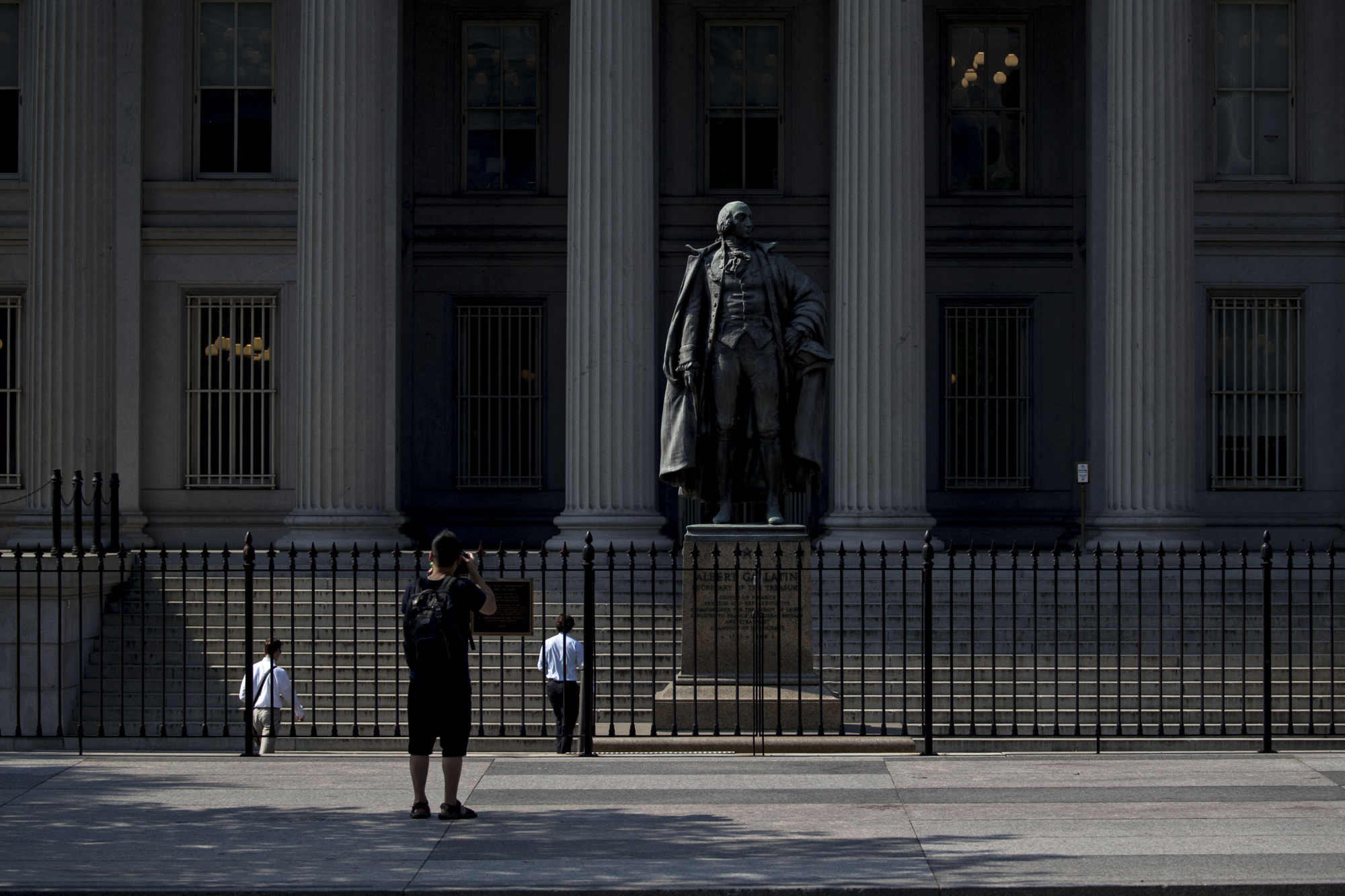 A visitor takes a photograph outside the U.S. Treasury building in Washington, D.C.