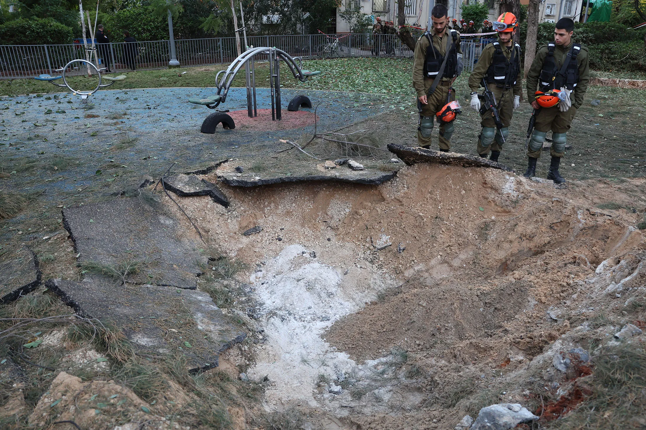 Israeli emergency responders inspect a crater at the site where a projectile fired from Yemen landed, in Tel Aviv early on Dec. 21.