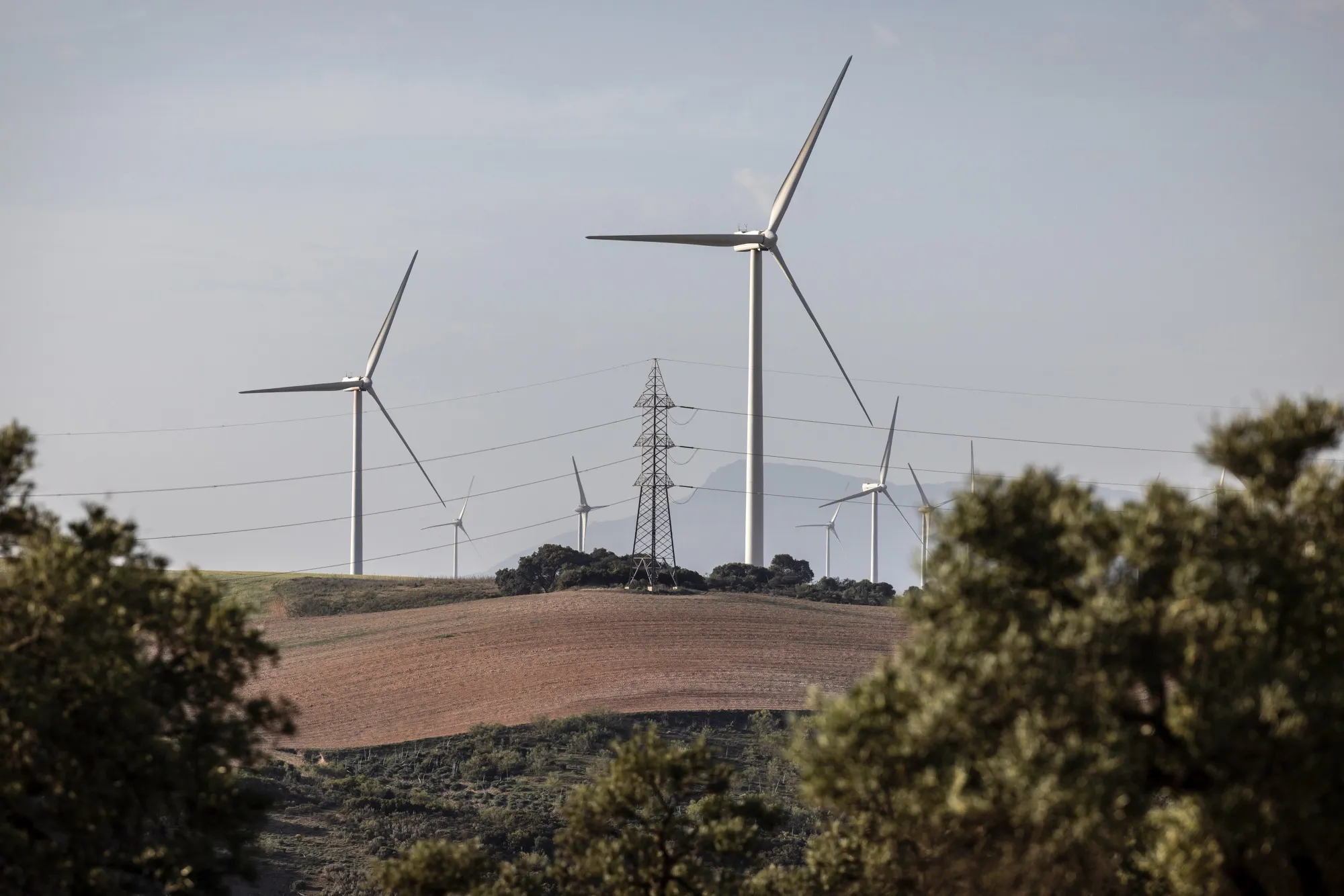 Electricity transmission tower and wind turbines in Sevilla, Spain.