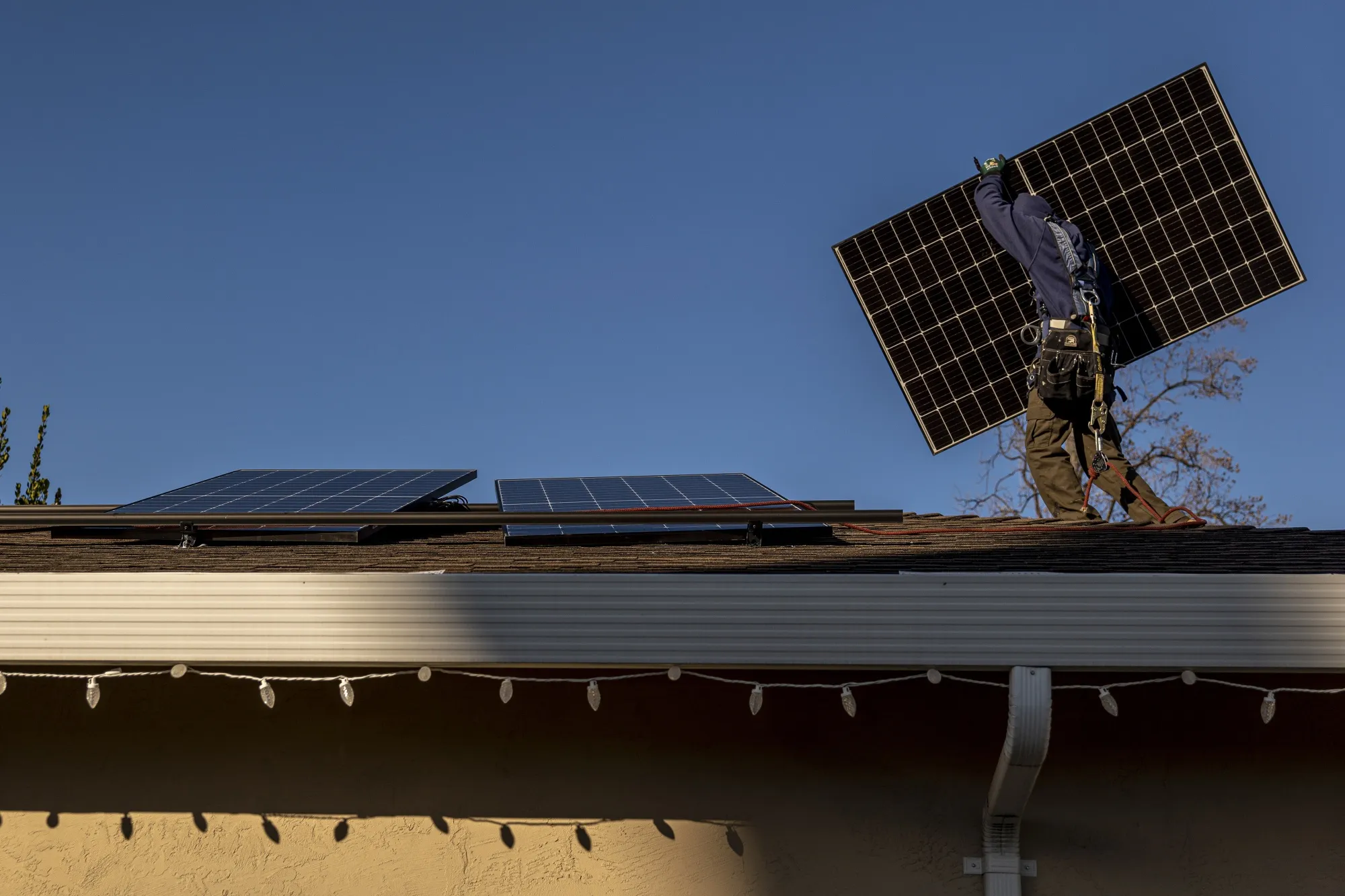 A contractor installs solar panels on the roof of a home in San Jose, California.