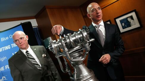 Jeff Bezos (R), the founder of Blue Origin and Amazon.com, gestures toward a model of the new BE-4 rocket engine during a press conference with Tory Bruno (L), CEO of United Launch Alliance, at the National Press Club September 17, 2014 in Washington, DC.
