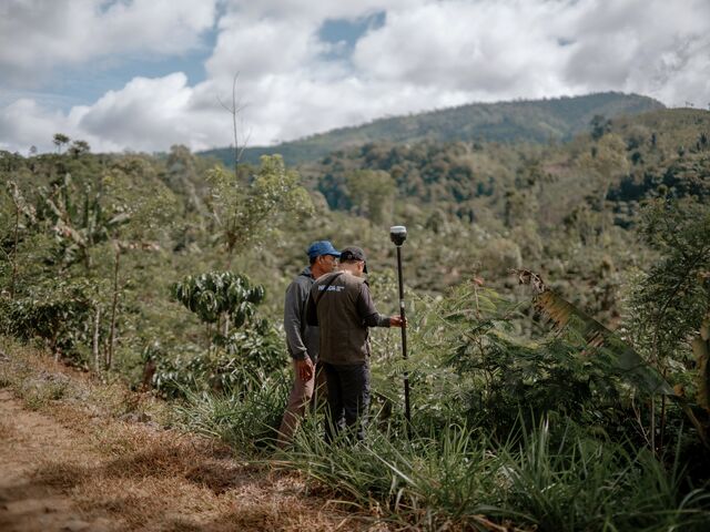 Ubaid Zulfirman, a surveyor for data company Meridia Land BV, assists coffee farmer Wiyono in mapping his land in the village of Ngarip.