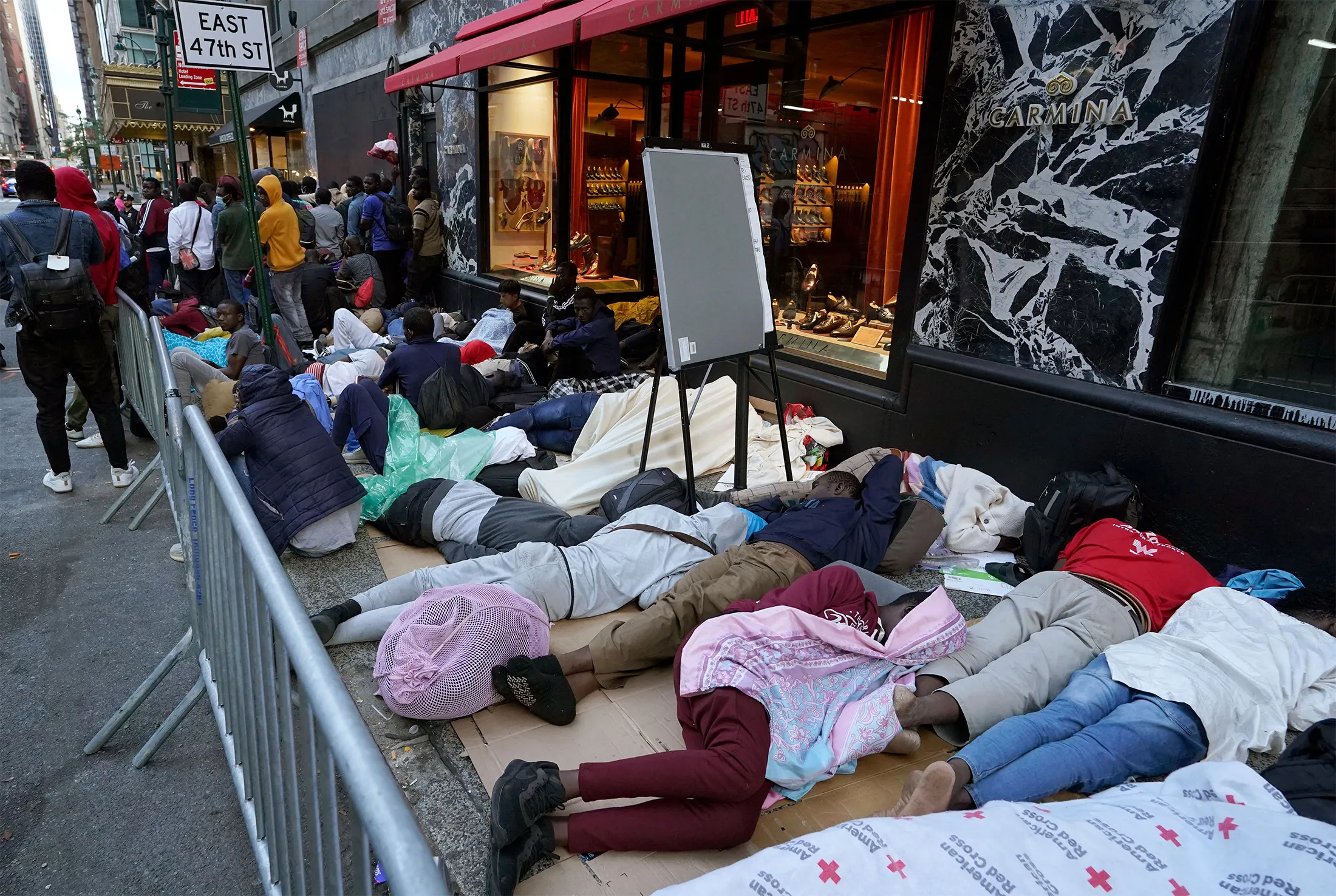 Migrantes duermen en fila afuera del Hotel Roosevelt el martes por la mañana.