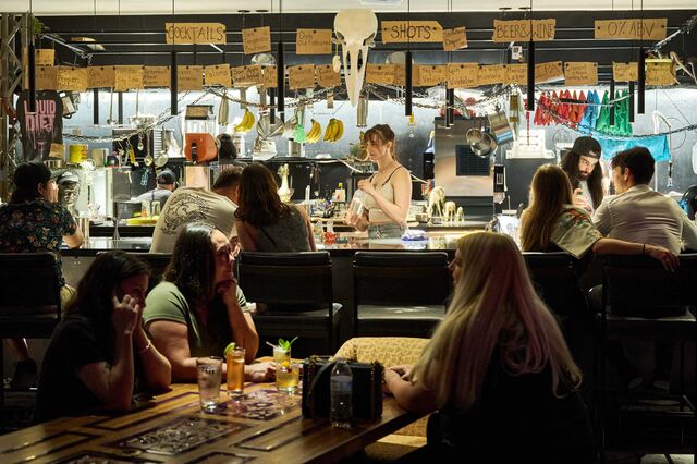 People enjoy cocktails inside the bar, Liquid Diet.