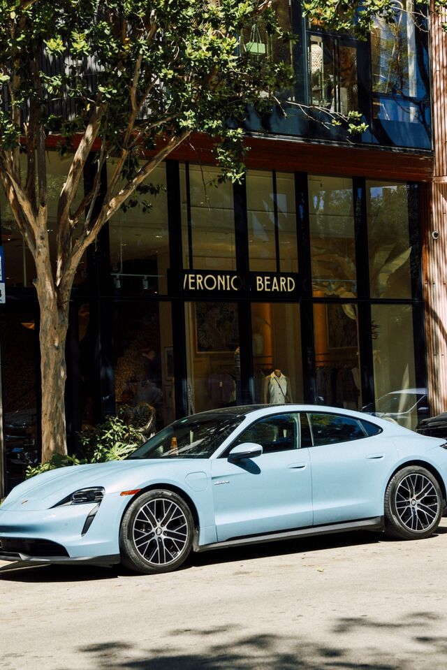 A blue Porshe parked outside the Veronica Beard store . 