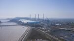 Photovoltaic panels at a solar farm and wind turbines near a coal fired power station in Jiaxing, Zhejiang province, China, last year.