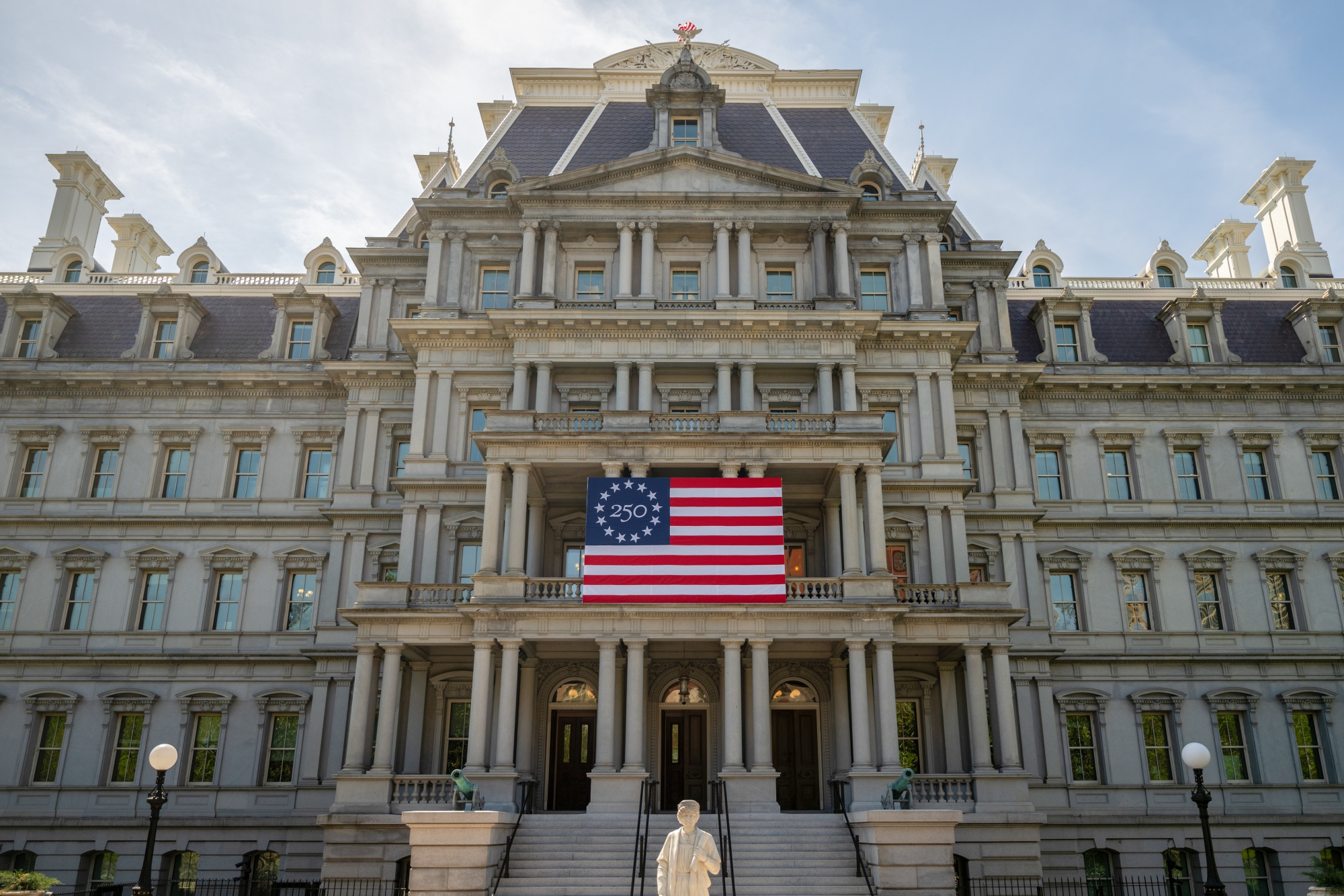 An America 250 flag outside the Eisenhower Executive Office Building near the White House in Washington, DC, US, on Thursday, April 9, 2026. The US will host a series of events throughout 2026 to celebrate the country's 250th anniversary. Photographer: Daniel Heuer/Bloomberg