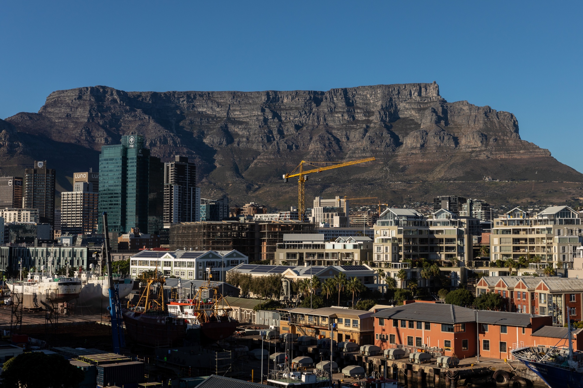 A construction crane near Table Mountain in Cape Town, South Africa, on Thursday, April 3, 2025. South Africa's ruling coalition risks unraveling after a dispute between its main members over proposed tax increases deepened, pummeling the rand. Photographer: Dwayne Senior/Bloomberg