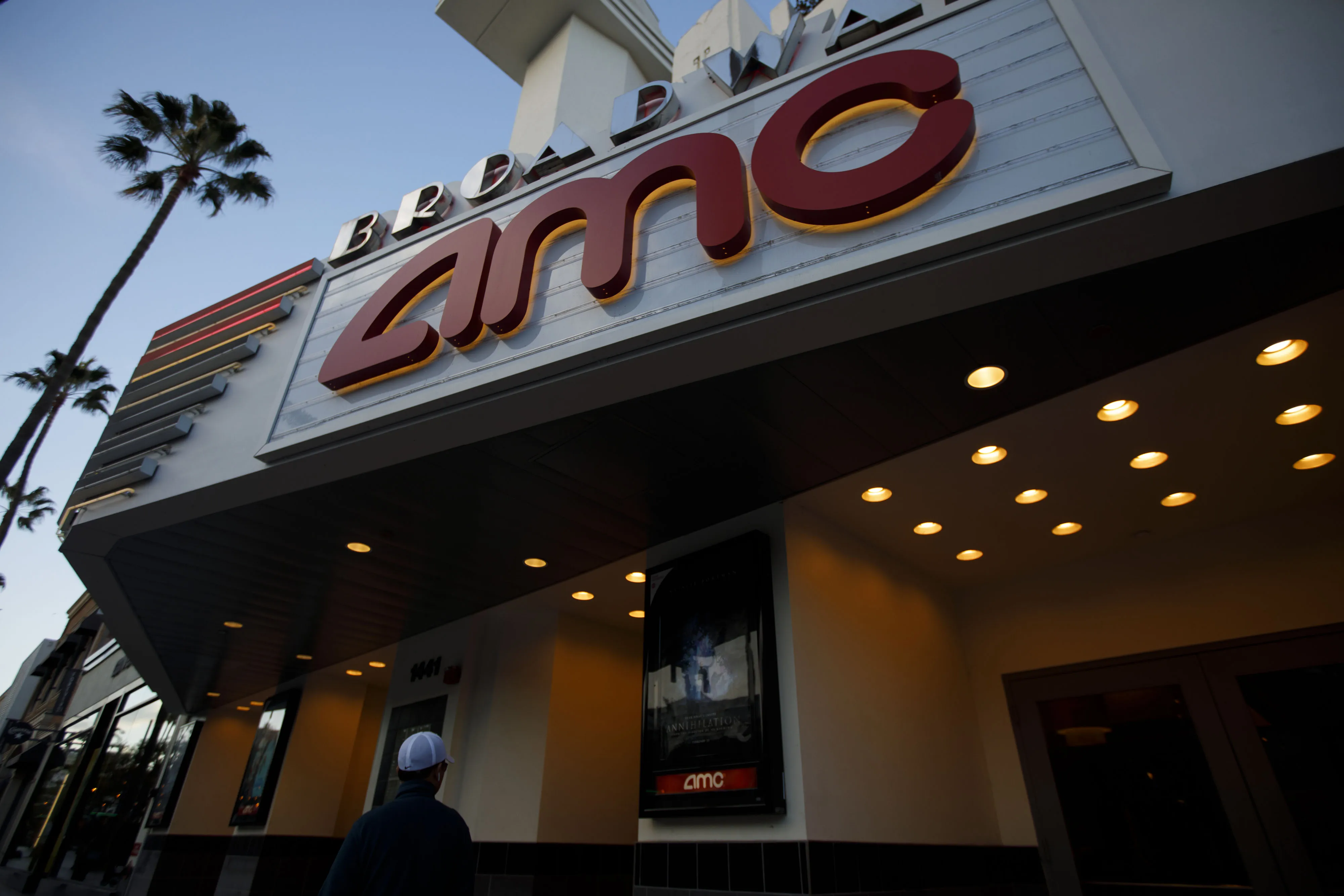 A pedestrian views a movie poster hanging on display outside an AMC Entertainment Inc. theater in Santa Monica, California.