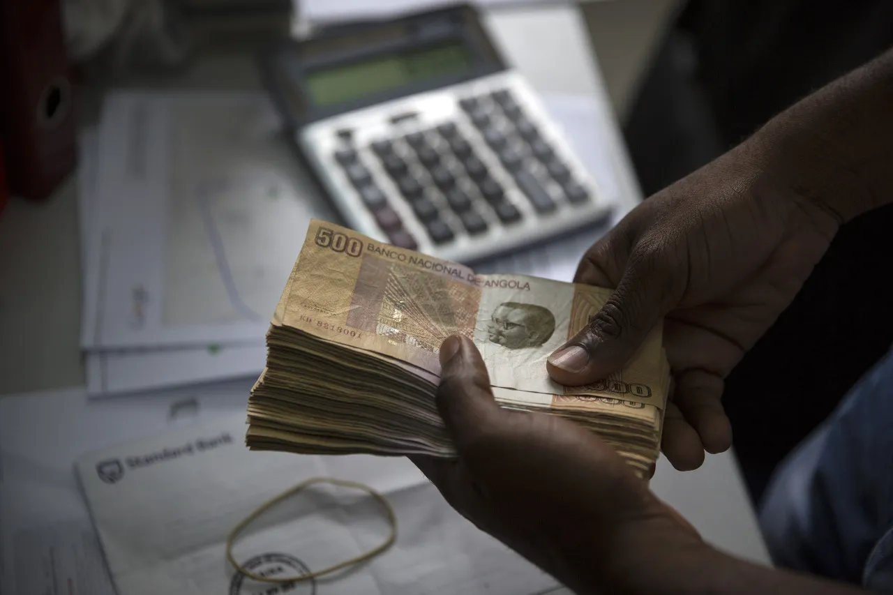 A worker counts Angolan Kwanza&nbsp;currency banknotes&nbsp;in Luanda, Angola.&nbsp;
