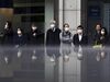 Pedestrians wearing face masks wait to cross a road in front of a monitor displaying stock information outside a securities firm on February 25 in Tokyo, Japan.