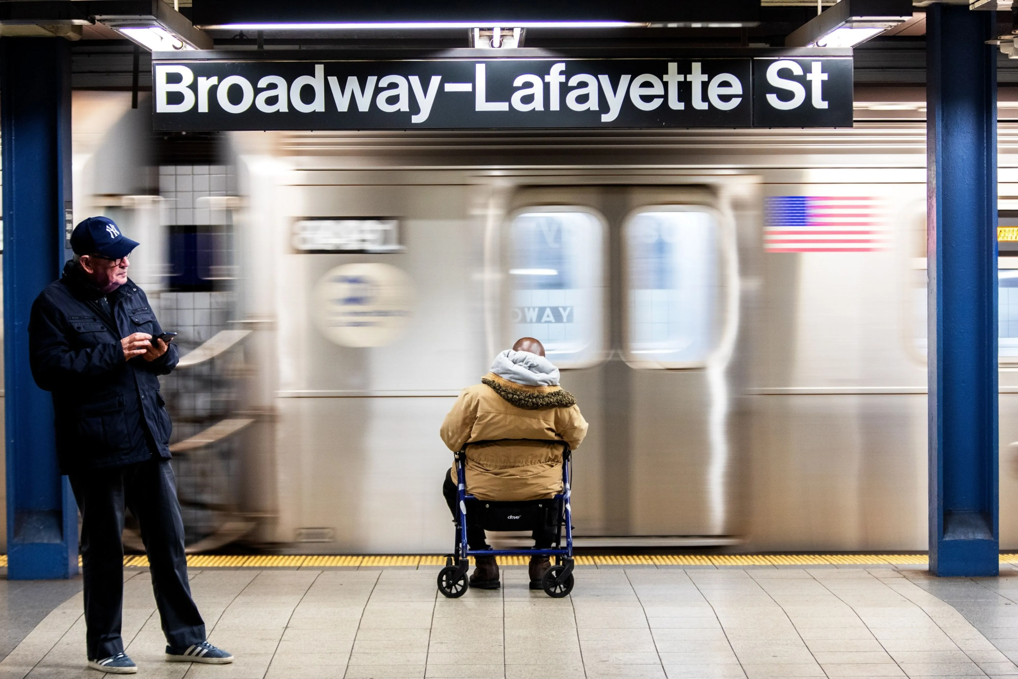 
Commuters wait on a platform at the Broadway-Lafayette Street subway station in New York in March.
