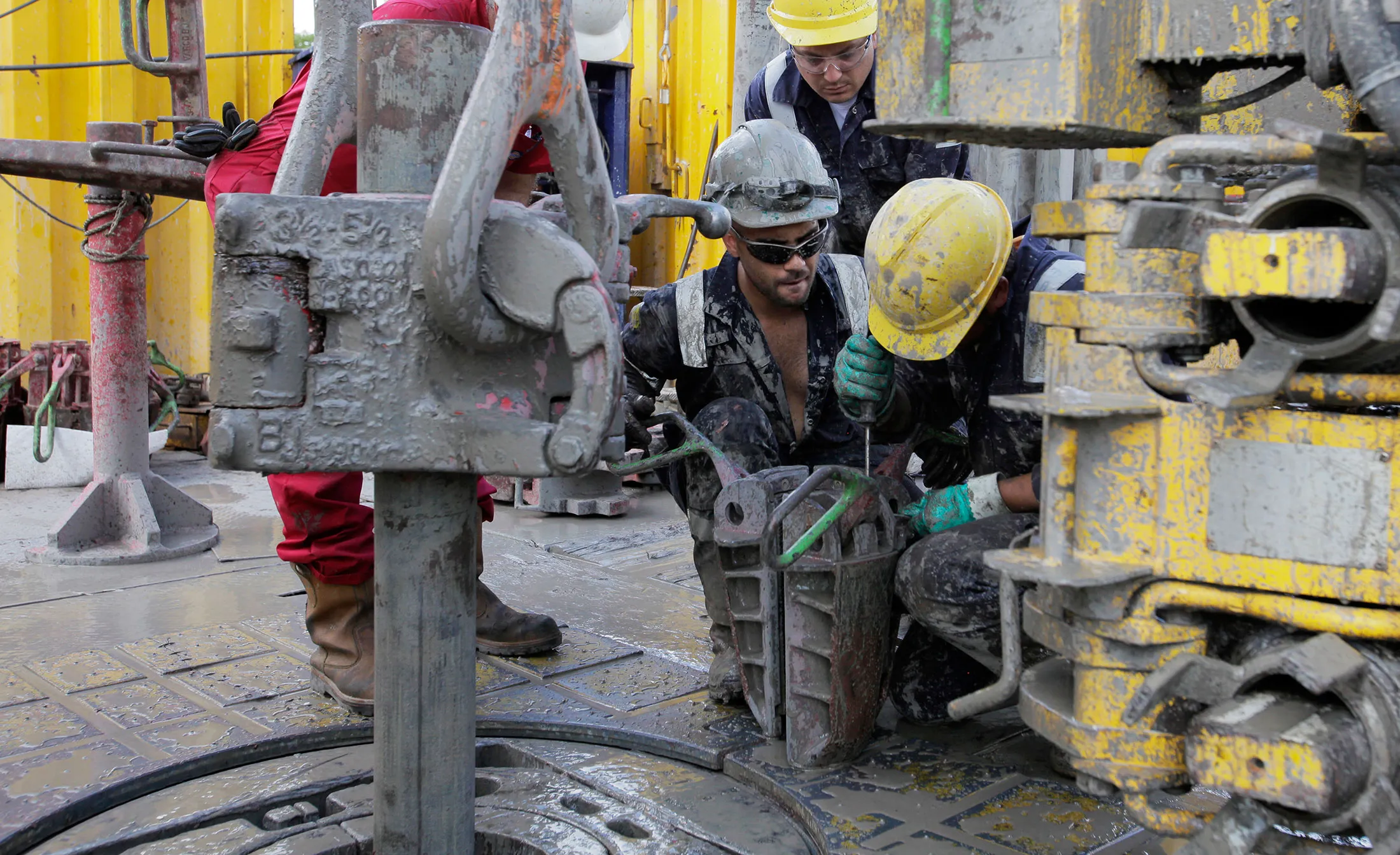 Rig hands from Schlumberger Ltd. work on a drilling rig at a geothermal energy extraction site in Villejuif, France.