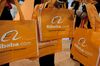 Alibaba.com Ltd. bags are distributed at the 2012 International Consumer Electronics Show (CES) in Las Vegas, Nevada, U.S., on Friday, Jan. 13, 2012. Alibaba Group Holding Ltd. is considering reducing the size of a loan for a potential Yahoo! Inc. acquisition to around $3 billion from the original target of $4 billion in order to use its cash instead.