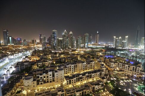 The city skyline sits illuminated at night in downtown Dubai, United Arab Emirates.