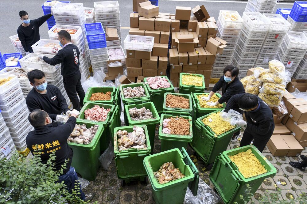 Employees of a catering company throw out expired food in Changsha, March 2020.