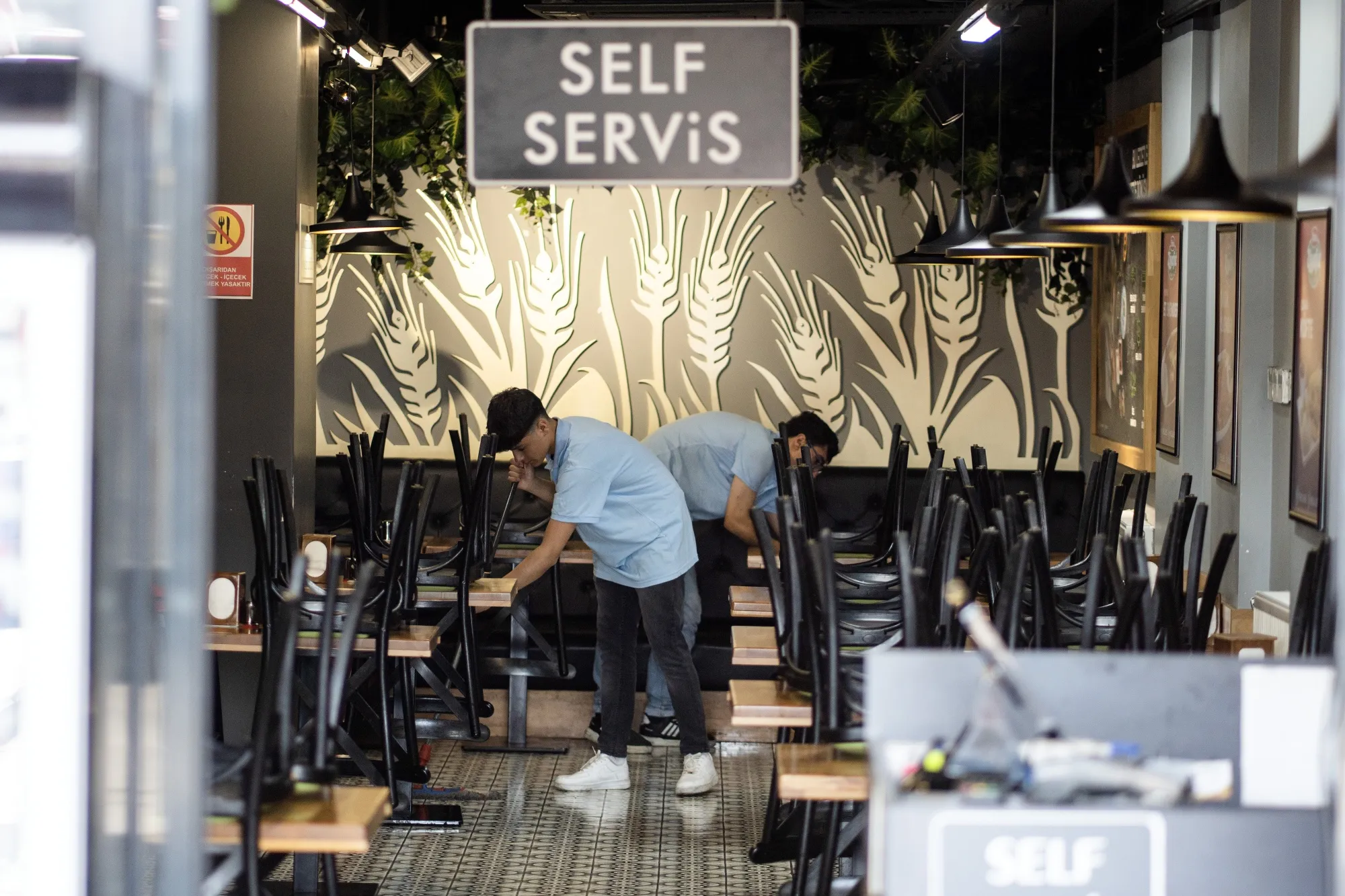 Workers clean the floor of a self service cafe area in Ankara, Turkey.
