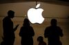 Employees stand in an Apple retail store.