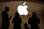 Employees stand in an Apple retail store.